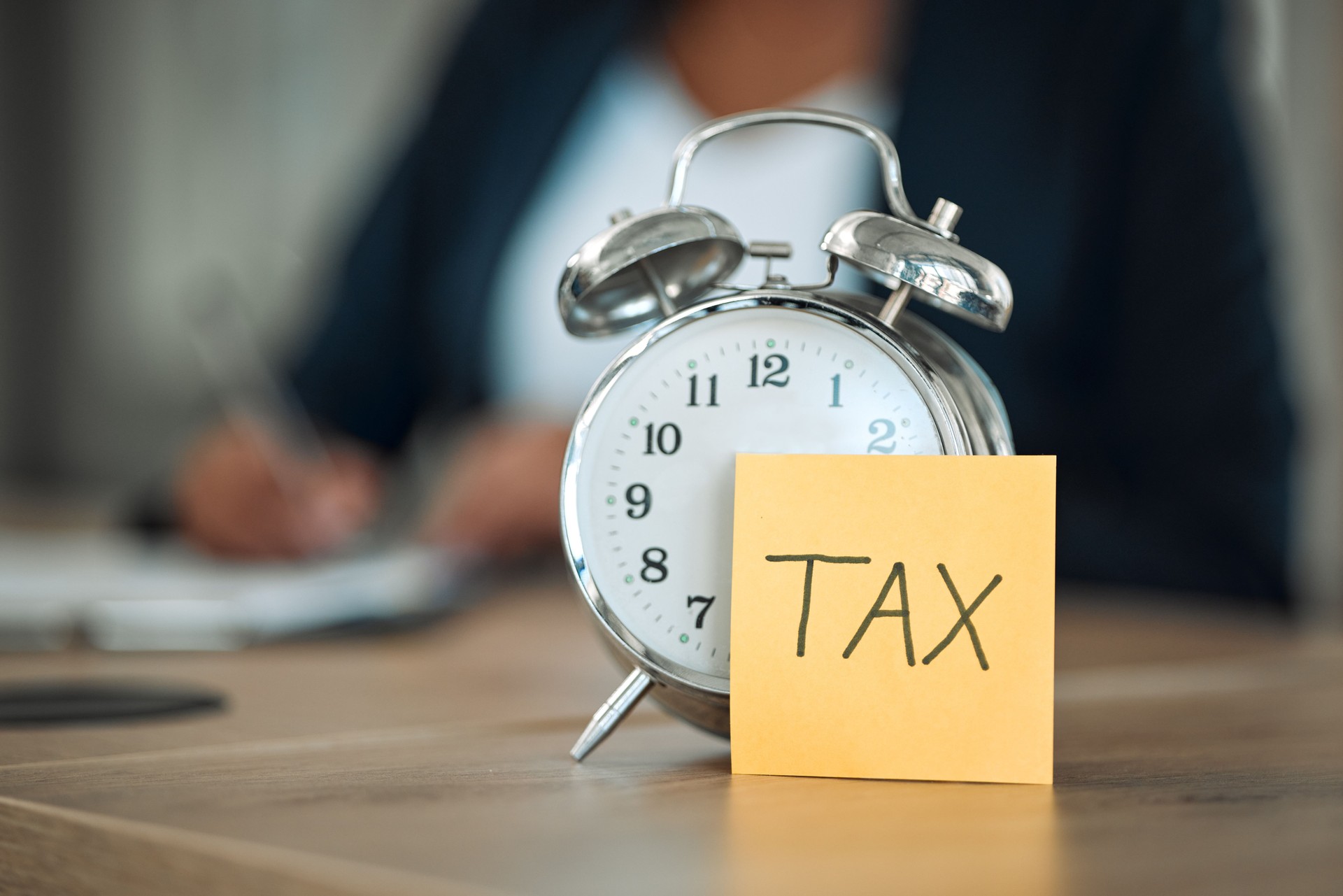 Taxes, clock and business person writing for financial report, accounting paperwork and documents or checklist. Clipboard, application reminder and professional people with clipboard, notes and time